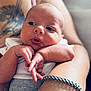 Caspiayn joined the competition — help win amazing prizes! baby, newborn, infant, arm, hand, tattoo, bracelet, skin, portrait, closeup, person, cute, expression, resting, clothing, white_shirt, gray_pants, adult, holding, soft_light