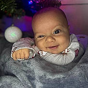 Caspiayn joined the competition — help win amazing prizes! baby, blanket, child, christmas_tree, closeup, clothing, cozy, cute, expression, face, happy, holiday, indoors, infant, ornament, person, portrait, smile, soft, warmth