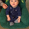 baby, child, infant, onesie, blue_clothing, green_chair, carpet, indoor, person, hands, support, cute, wide_eyes, sitting, plush_chair, portrait, young_child, comfort, looking_up, casual