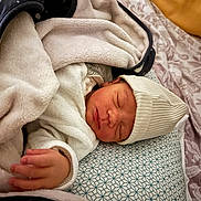 Karel a rejoint le concours — aidez-le/la à gagner de superbes lots ! baby, newborn, blanket, beanie, pillow, bed, bedding, sleeping, infant, swaddle, hand, face, cheek, soft_texture, pattern, fabric, portrait, closeup, cozy, nursery