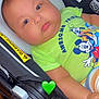 baby, car_seat, child, closeup, comfort, cute, disney_characters, donald_duck, expressionless, face, furniture, goofy, green_shirt, heart_emoji, indoors, infant, mickey_mouse, plush, seatbelt_warning, soft_skin