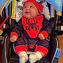 Dominic is registered to the contest to win money with this photo: baby, baby_girl, black, blanket, car_seat, child, clothing, cute, happy, headwear, indoors, infant, portrait, red, safety, seatbelt, smiling, spiderman_costume, white_socks, young_child