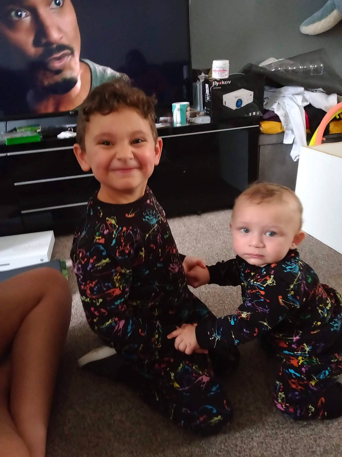 Graysen is registered to the contest to win money with this photo: baby_toddler_clothing, black, child, event, eye, face, facial_expression, flooring, fun, hairstyle, happy, iris, joy, lap, person, room, skin, sleeve, smile, standing