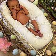 Daxton is registered to the contest to win money with this photo: baby, blanket, child, cradle, cushion, cute, decorations, indoor, infant, newborn, nursery, pastel_eggs, peaceful, person, polka_dot_carpet, resting, rope_handle, sleeping, small, soft