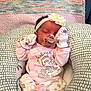 Henslee joined the competition — help win amazing prizes! baby, newborn, infant, sleeping, pacifier, flower_headband, mittens, nursing_pillow, blanket, pink_clothing, medical_tube, cute, cozy, portrait, indoor, soft_texture, pattern, head, knitted_blanket, cartoon_design