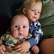 Cayden joined the competition — help win amazing prizes! child, baby, toddler, couch, clothing, blue, green, face, hand, sitting, indoor, expression, food, closeup, family, portrait, cute, young, two_children, hugging
