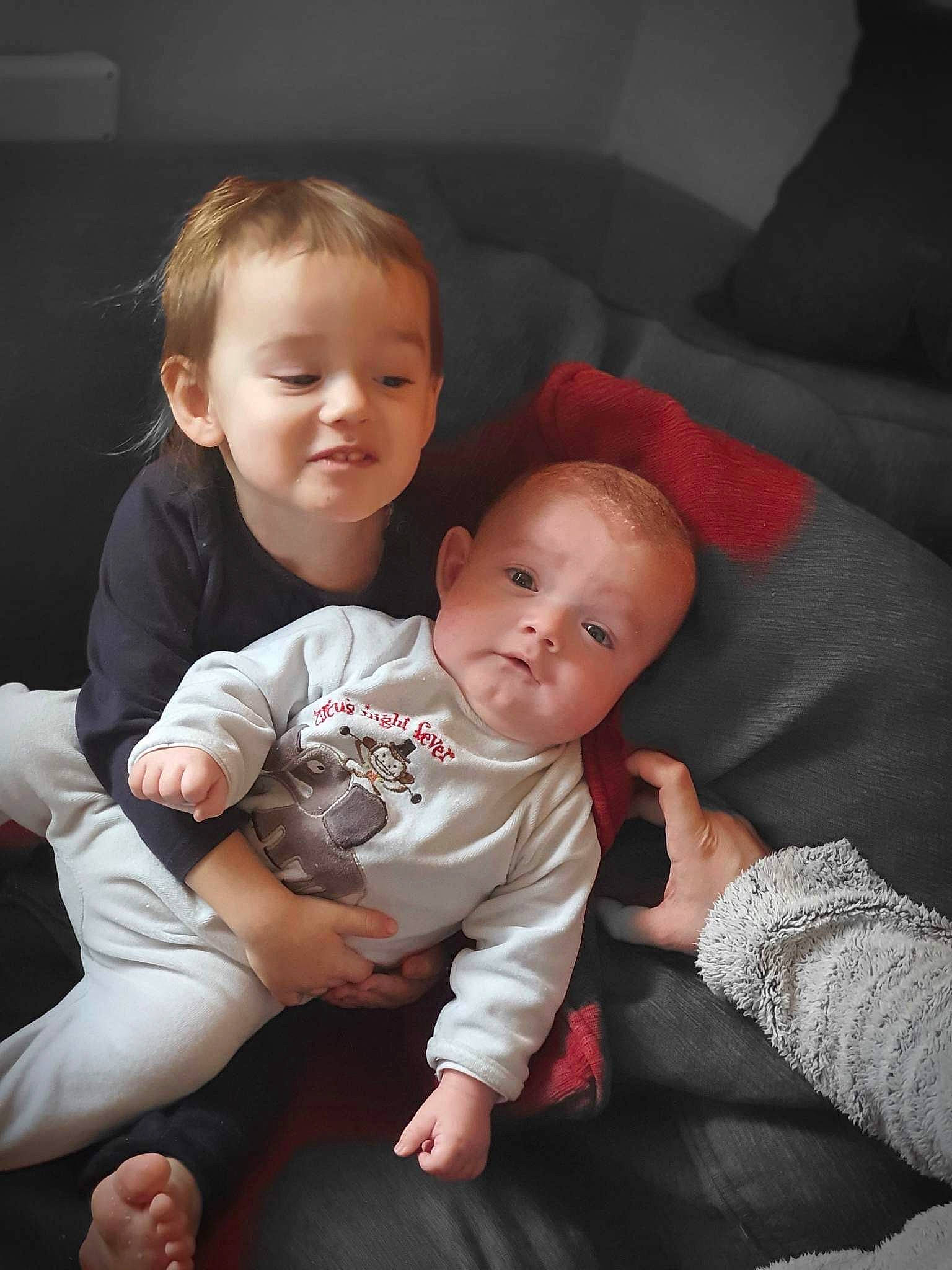Lina participe au concours pour gagner de l'argent avec cette photo : arm, baby, baby_toddler_clothing, cheek, comfort, couch, finger, flash_photography, gesture, hand, happy, interaction, iris, lap, mouth, person, skin, smile, toddler, trunk