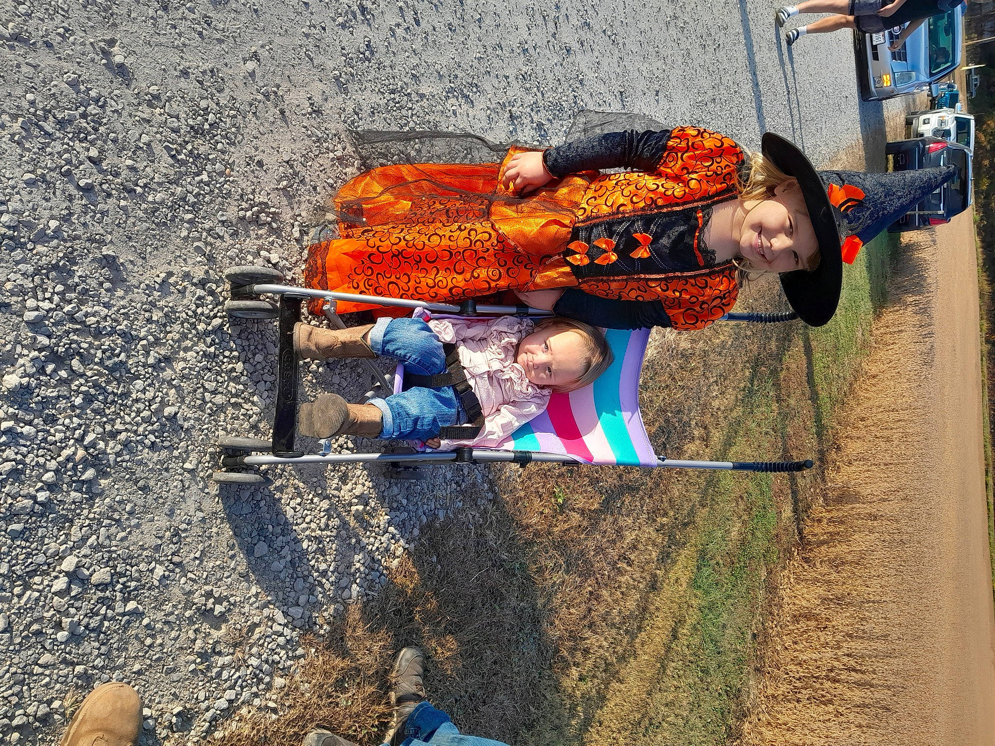 Kylie is registered to the contest to win money with this photo: asphalt, blue, child, city, concrete, electric_blue, fun, headwear, joy, landscape, leisure, people_in_nature, person, road, road_surface, shadow, sidewalk, sitting, soil, street