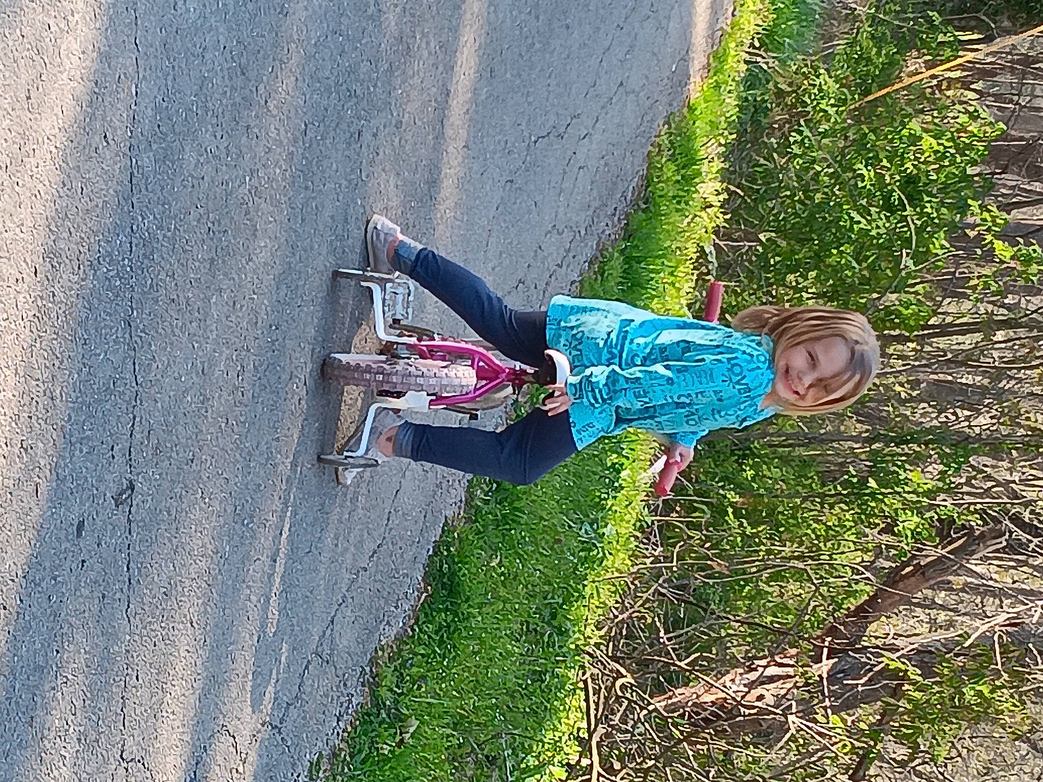 Kylie is registered to the contest to win money with this photo: adventure, asphalt, electric_blue, grass, joy, landscape, leisure, people_in_nature, person, plant, recreation, road, road_surface, shadow, shrub, sidewalk, tar, tints_and_shades, tire, toddler