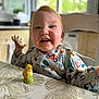 Ayden a rejoint le concours — aidez-le/la à gagner de superbes lots ! toddler, child, messy_face, bib, table, toy, yellow_chick, highchair, kitchen, window, natural_light, smiling, happy, indoor, clothing, tablecloth, gesturing, face, person, young_child