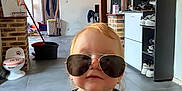 Ayden participe au concours pour gagner de l'argent avec cette photo : toddler, child, sunglasses, aviator, spider_man, shirt, indoor, floor, tiles, shoes, cabinet, bucket, mop, household, person, portrait, hair, face, cute, funny