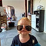 toddler, child, sunglasses, aviator, spider_man, shirt, indoor, floor, tiles, shoes, cabinet, bucket, mop, household, person, portrait, hair, face, cute, funny
