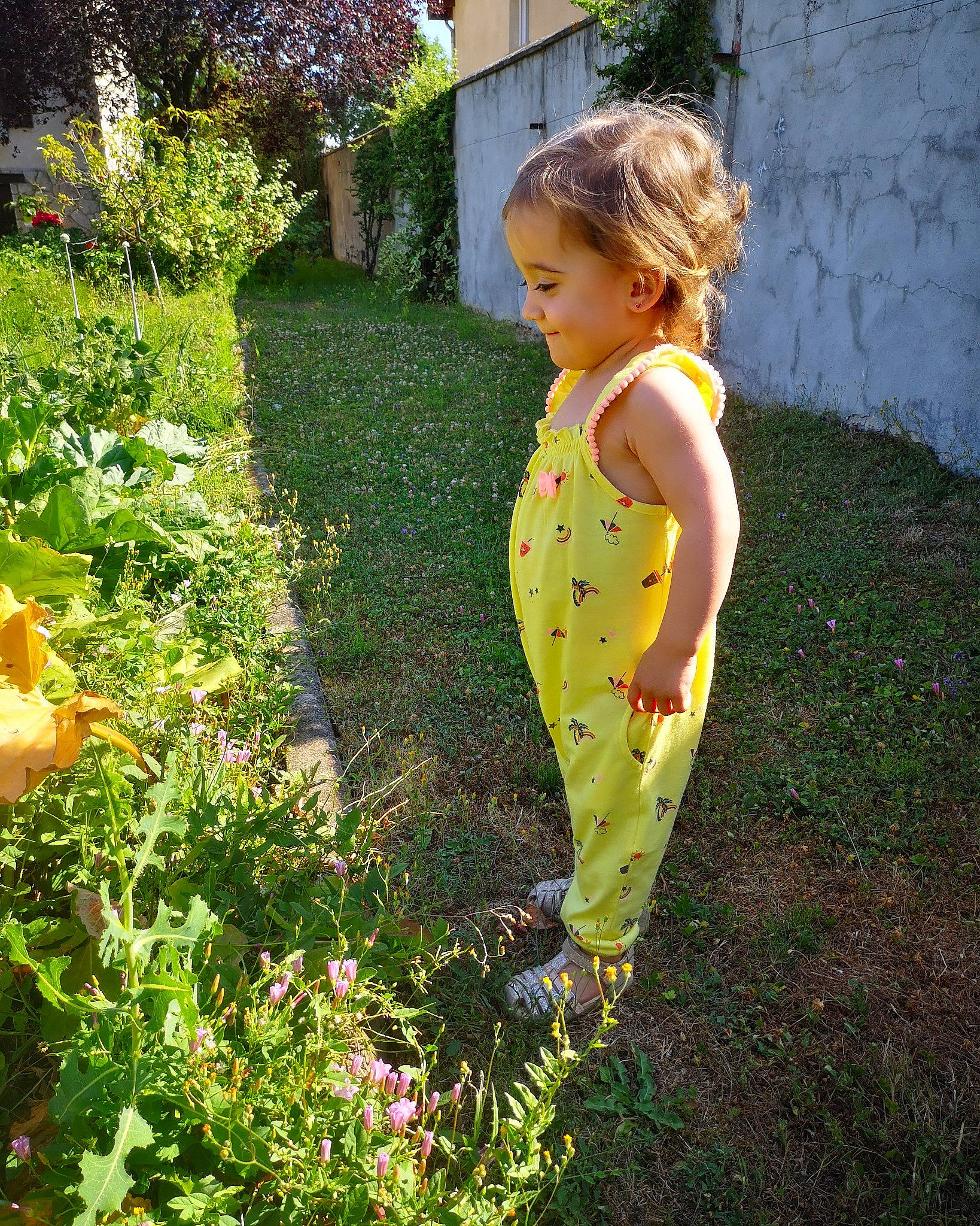 Lia participe au concours pour gagner de l'argent avec cette photo : backyard, botany, child, dress, fawn, flower, garden, grass, leaf, pattern, person, plant, shrub, spring, summer, toddler, tree, wildflower, yard, yellow