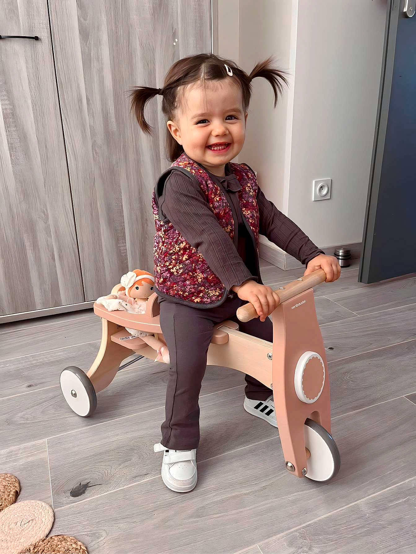 Nina participe au concours pour gagner de l'argent avec cette photo : baby_toddler_clothing, child, comfort, door, flooring, fun, happy, human_leg, joy, knee, person, shoe, sitting, sleeve, smile, snapshot, sneakers, sock, thigh, toddler