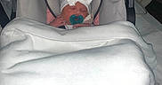 Devahni is registered to the contest to win money with this photo: newborn, baby, car_seat, blanket, pacifier, hat, sleeping, indoors, infant, white_blanket, pink_car_seat, baby_clothing, headwear, child, portrait, baby_accessory, soft_texture, resting, cozy, wrapped