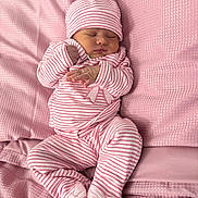 Devahni joined the competition — help win amazing prizes! baby, newborn, sleeping, pink, striped_clothing, hat, blanket, soft_texture, cozy, infant, cute, sleep, rest, child, footwear, pajamas, bed, portrait, peaceful, indoors