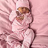 baby, newborn, sleeping, pink, striped_clothing, hat, blanket, soft_texture, cozy, infant, cute, sleep, rest, child, footwear, pajamas, bed, portrait, peaceful, indoors