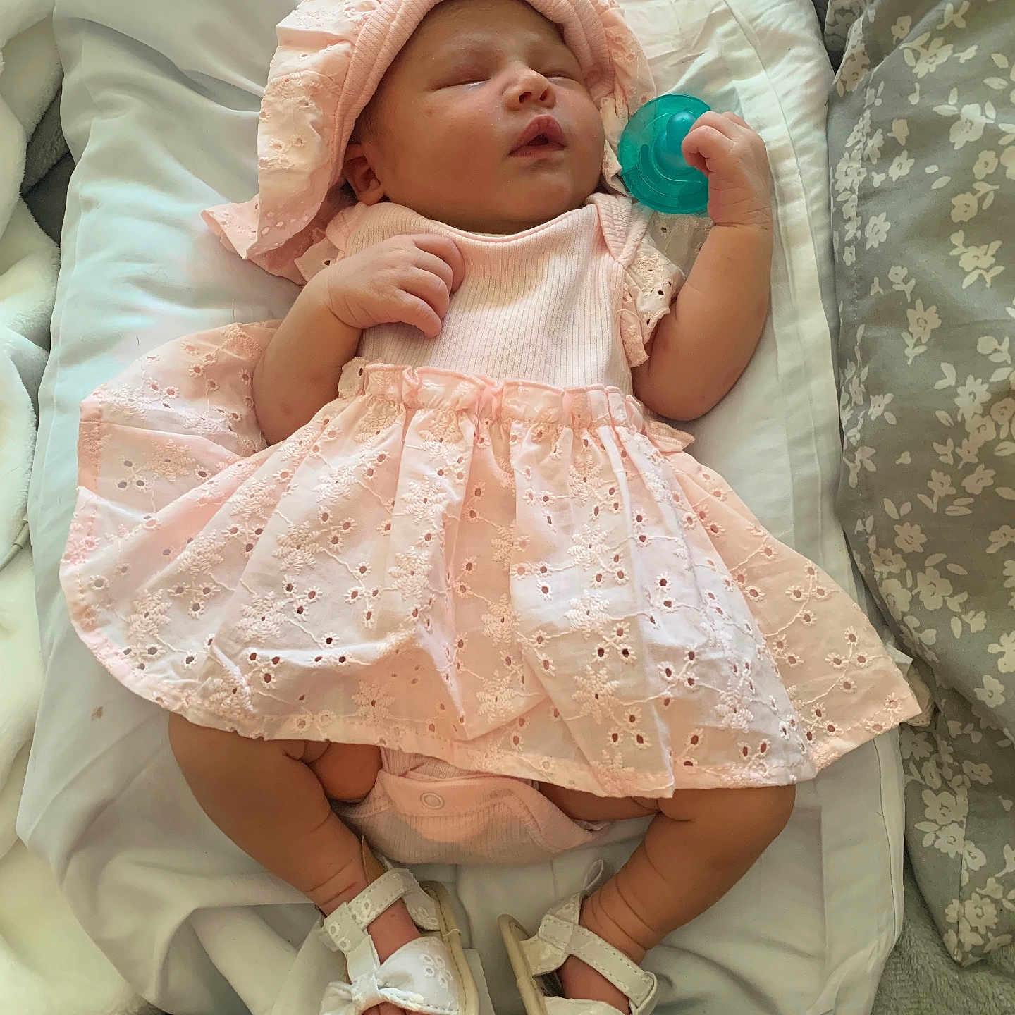 Devahni is registered to the contest to win money with this photo: baby, sleeping, pink_dress, bonnet, pacifier, cushion, blanket, footwear, sandals, infant, indoors, soft_lighting, cozy, resting, closeup, person, child, cute, comfort, home
