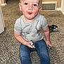 toddler, child, barefoot, carpet, toy_car, jeans, gray_shirt, indoor, home, curious, sitting, carpeted_floor, short_hair, blue_eyes, casual_clothing, playing, expression, young_child, person, floor_vent