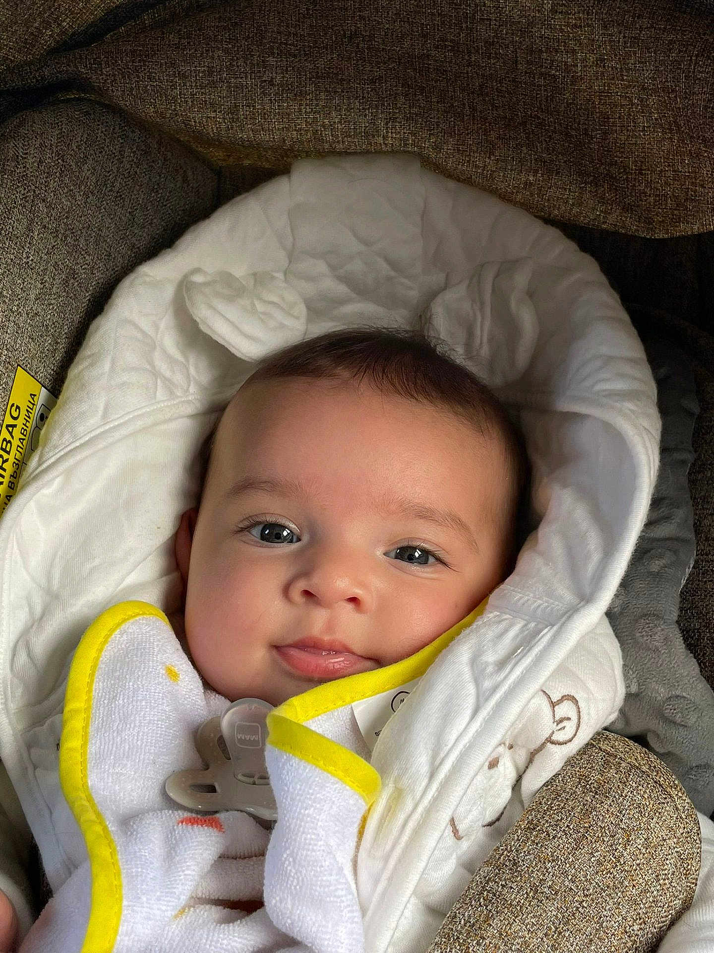 Maīna a rejoint le concours — aidez-le/la à gagner de superbes lots ! baby, blanket, pacifier, cushion, face, infant, smile, clothing, fabric, seat, closeup, head, child, portrait, cozy, soft, indoor, comfort, cute, young