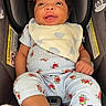 baby, infant, car_seat, smiling, headband, bib, floral_outfit, clothing, happy, child, seatbelt, safety, portrait, closeup, indoor, person, cute, young_child, red_headband, small_child