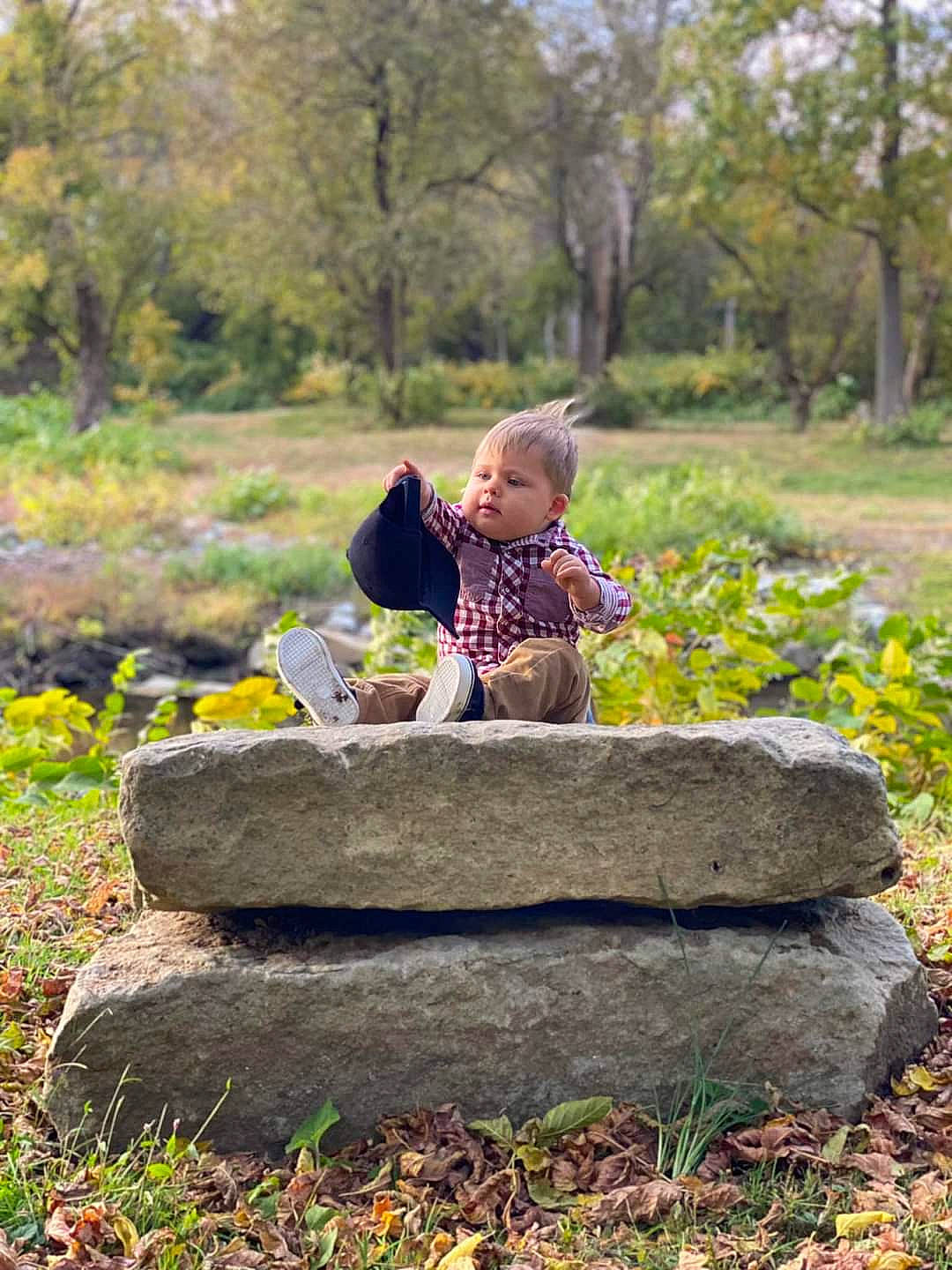 Cameron is registered to the contest to win money with this photo: baby, baby_toddler_clothing, child, forest, grass, groundcover, happy, jacket, landscape, leisure, natural_landscape, people_in_nature, person, plant, sitting, soil, toddler, tree, wood, woodland