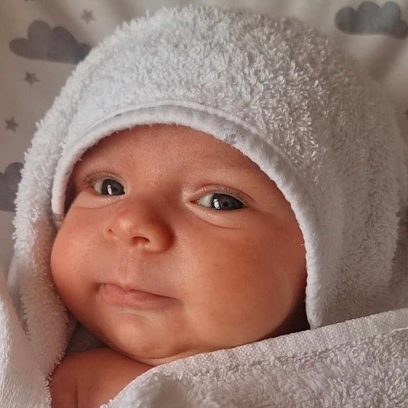 Rego is registered to the contest to win money with this photo: baby, background, child, closeup, clouds, cute, expression, eyes, face, fluffy, head, infant, newborn, portrait, skin, soft, stars, towel, white, wrapped