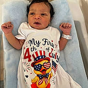 Khazari is registered to the contest to win money with this photo: 4th_of_july, baby, blue_blanket, celebration, clothing, cute, duck_illustration, expression, face, holiday, hospital_bracelet, indoor, infant, lying_down, newborn, onesie, patriotic, person, portrait, small_hands
