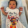 4th_of_july, baby, blue_blanket, celebration, clothing, cute, duck_illustration, expression, face, holiday, hospital_bracelet, indoor, infant, lying_down, newborn, onesie, patriotic, person, portrait, small_hands