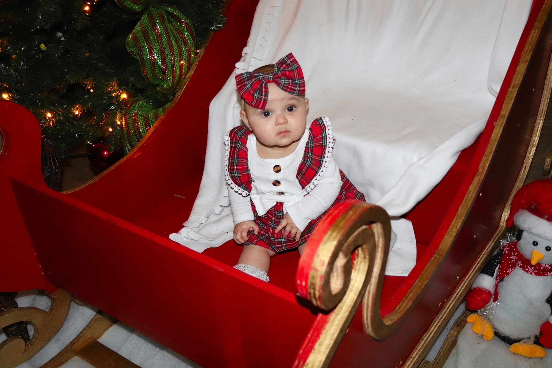Melaiya joined the competition — help win amazing prizes! baby, bow, celebration, child, christmas_tree, cute, decorations, festive, holiday, indoor, infant, penguin, plaid, red, seasonal, sleigh, stuffed_animal, toy, white, winter