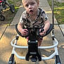 baby, bicycle, e_scooter, face, furniture, grass, head, machine, nature, outdoors, park, person, photography, plant, portrait, spoke, stroller, transportation, vehicle, wheel