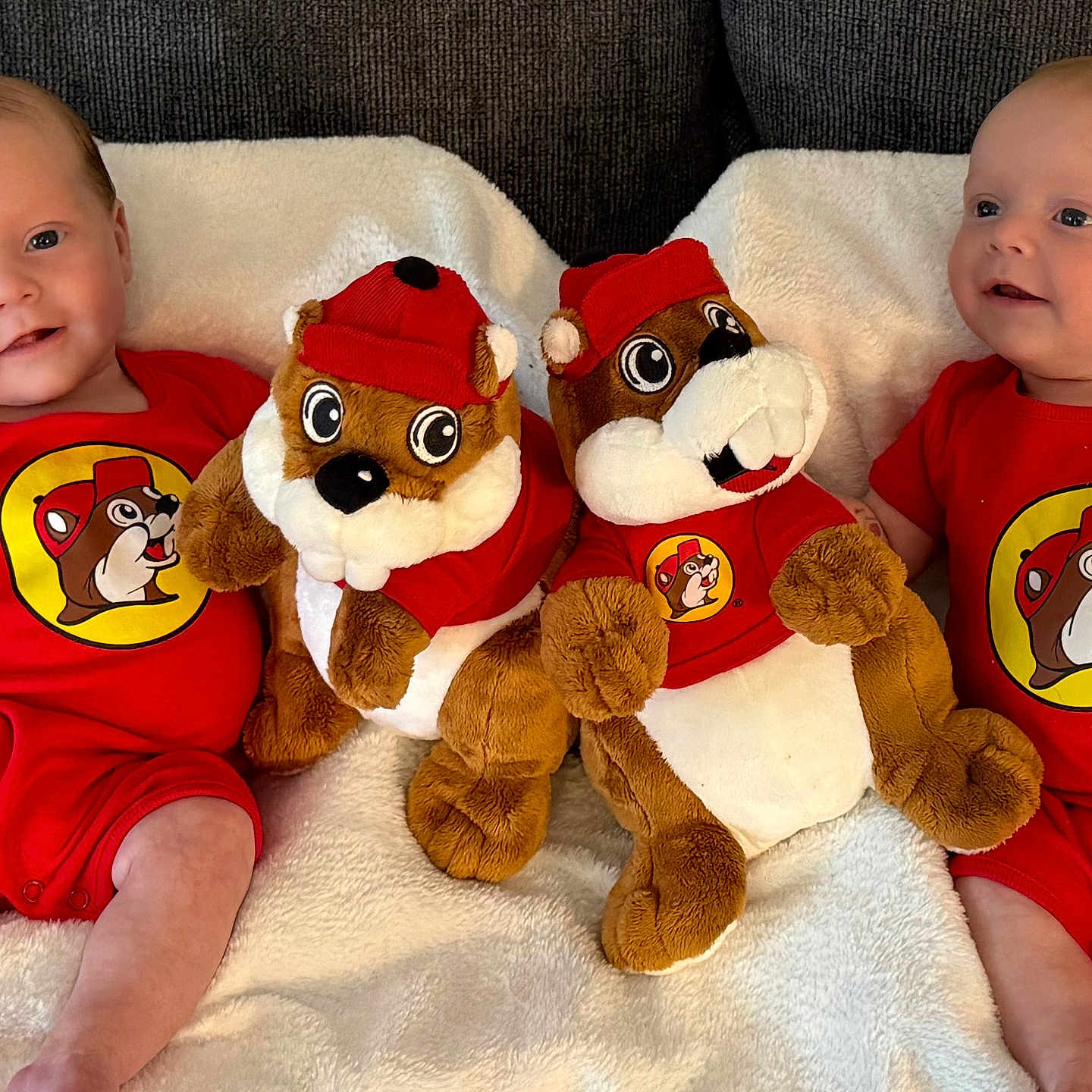 James And Matthew is registered to the contest to win money with this photo: baby, beaver, blanket, child, clothing, couch, cute, face, happy, indoor, infant, plush_toy, portrait, red_onesie, sitting, smiling, soft_toy, toddler, toy, twin