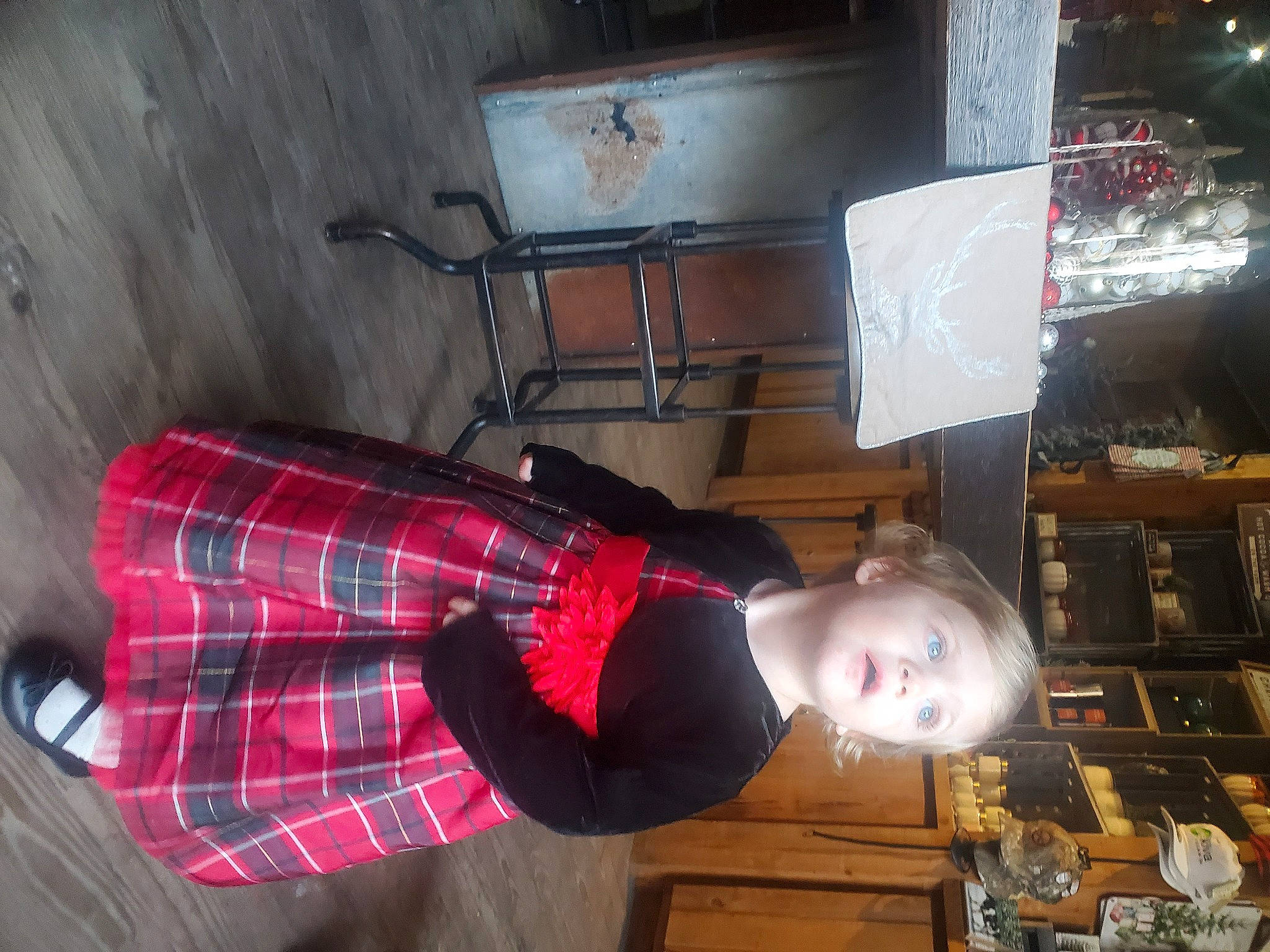 Lilianna is registered to the contest to win money with this photo: flooring, house, pattern, person, plaid, room, shelf, suit, surprise, tartan, toddler, wood