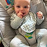 baby, child, infant, portrait, smiling, happy, sitting, bouncer, cushion, blanket, toy, colorful, indoor, home, face, hands, fist, clothing, bib, baby_gear