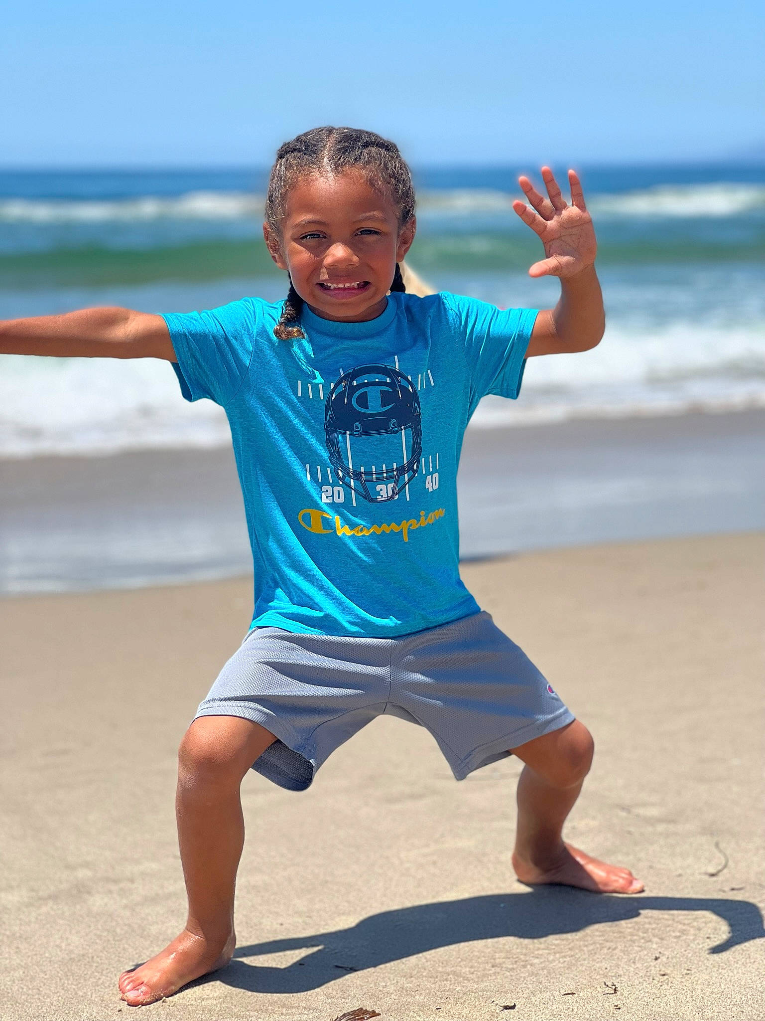 Dominick is registered to the contest to win money with this photo: azure, barefoot, beach, electric_blue, foot, fun, gesture, happy, joy, knee, leisure, people_in_nature, people_on_beach, person, sky, sleeve, smile, summer, t_shirt, thigh