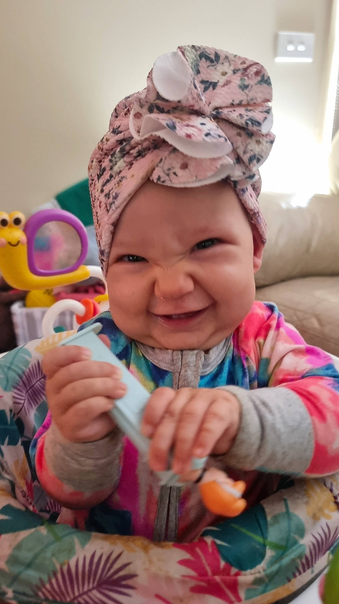 Willow is registered to the contest to win money with this photo: baby, cap, cheek, eye, facial_expression, finger, fun, gesture, hand, happy, headwear, human, joy, lip, mouth, nose, organ, people, person, pink