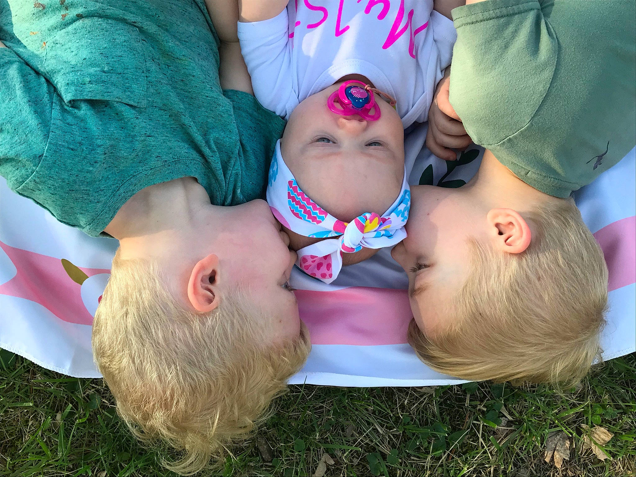 Embri is registered to the contest to win money with this photo: baby, child, ear, fun, grass, hair_accessory, happy, head, headwear, interaction, mouth, person, pink, plant, play, toddler