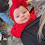Këyla a rejoint le concours — aidez-le/la à gagner de superbes lots ! baby, infant, child, red_bow, headband, red_hat, baby_carrier, carrier, adult, jacket, coat, outdoor, pavement, sunlight, blue_eyes, cheeks, winter_clothing, boots, portrait, smile