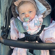 Këyla a rejoint le concours — aidez-le/la à gagner de superbes lots ! baby, stroller, pacifier, headband, pink_snowsuit, fur_trim, seatbelt, buckle, blue_eyes, infant, hood, blanket, beaded_chain, toy_clip, cheeks, handlebar, outerwear, portrait, indoors_outdoors, closeup