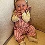 Lillie is registered to the contest to win money with this photo: baby, child, smile, headband, overalls, pink, striped, socks, couch, beige, happy, indoor, portrait, cute, infant, hands, cheerful, soft_lighting, seated, cozy
