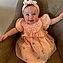 Lillie joined the competition — help win amazing prizes! baby, child, smiling, headband, dress, peach_color, chair, seated, cute, happy, indoors, person, face, socks, embroidery, soft_fabric, young_child, puffed_sleeves, comfort, portrait
