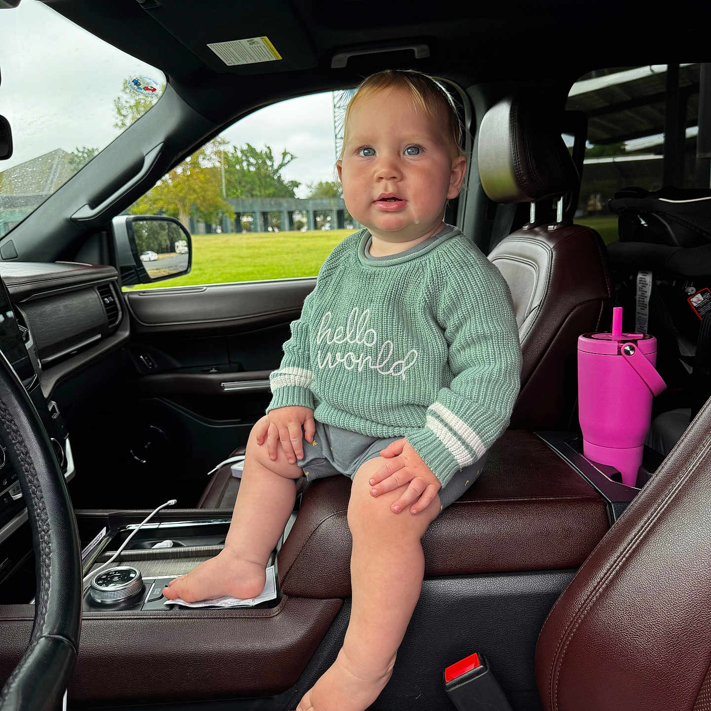 Brock joined the competition — help win amazing prizes! toddler, child, baby, car_interior, seat, leather_seat, sweater, barefoot, drool, center_console, pink_tumbler, window, daylight, green_sweater, curious_expression, head, face, hand, foot, seatbelt