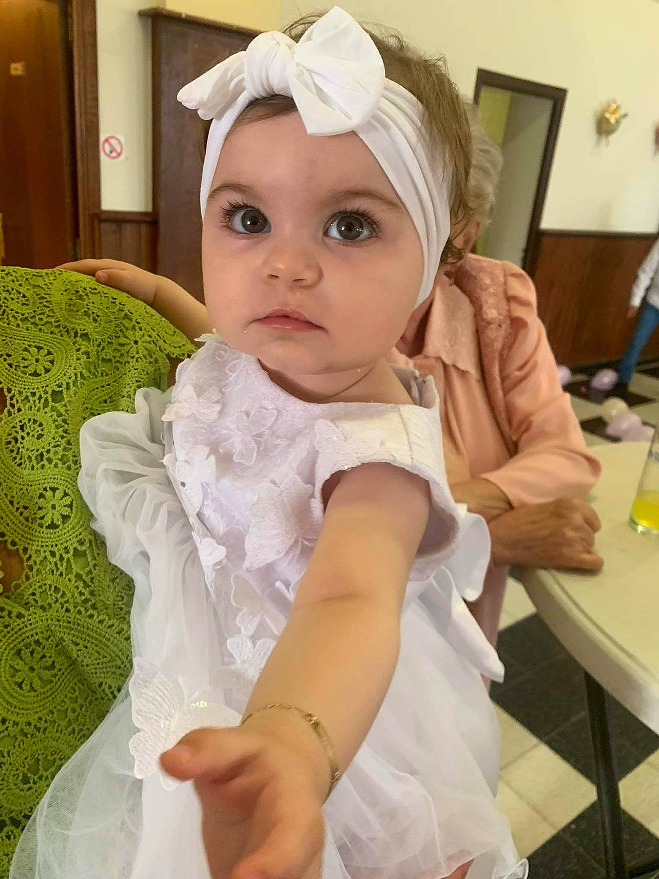 Tessia participe au concours pour gagner de l'argent avec cette photo : baby, baby_toddler_clothing, bridal_accessory, chair, cheek, child, dress, embellishment, event, eye, fashion_accessory, formal_wear, happy, headband, headgear, headpiece, headwear, human_body, person, sleeve