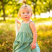 Aspen joined the competition — help win amazing prizes! child, toddler, girl, portrait, outdoor, park, sunlight, golden_hour, green_dress, ponytail, blonde_hair, standing, face, looking_at_camera, grass, trees, nature, daylight, fashion, bokeh
