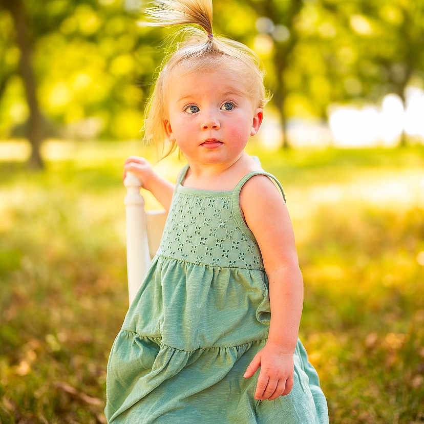 Aspen joined the competition — help win amazing prizes! child, toddler, girl, portrait, outdoor, park, sunlight, golden_hour, green_dress, ponytail, blonde_hair, standing, face, looking_at_camera, grass, trees, nature, daylight, fashion, bokeh