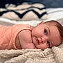adorable, baby, blanket, child, closeup, cozy, cute, expression, eyes, face, indoor, infant, lying_down, peach_clothing, portrait, resting, skin, sleeping, soft, young