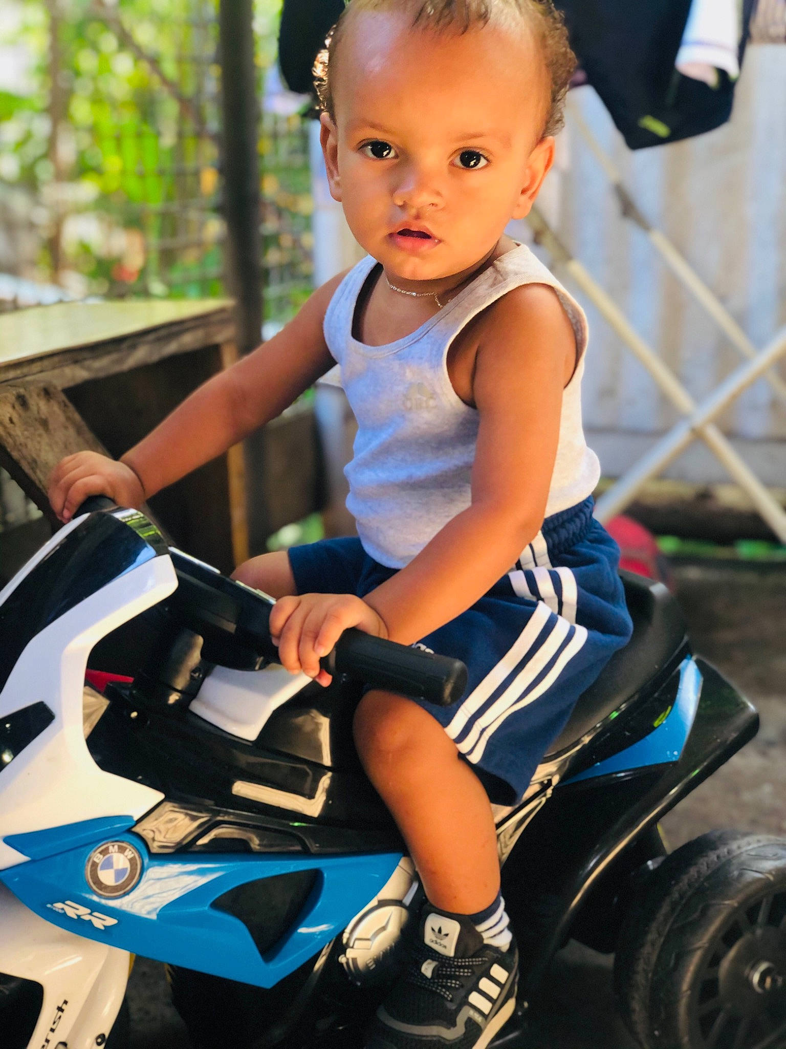 Jahyann a rejoint le concours — aidez-le/la à gagner de superbes lots ! automotive_design, automotive_lighting, automotive_tire, baby_toddler_clothing, black, blue, child, fender, hairstyle, happy, leisure, light, motor_vehicle, person, photograph, riding_toy, shorts, tire, toddler, wheel