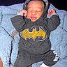 Zymir is registered to the contest to win money with this photo: baby, sleeping, hoodie, batman_logo, pacifier, towel, clothing, infant, cute, cozy, resting, hands_up, closed_eyes, soft_texture, indoor, person, apparel, newborn, relaxed, white_socks