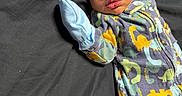 Zymir joined the competition — help win amazing prizes! baby, black_background, child, clothing, cozy, cute, dinosaur_pattern, indoors, infant, lying_down, mitten, newborn, onesie, peaceful, person, portrait, sleep, sleeping, soft, young_child