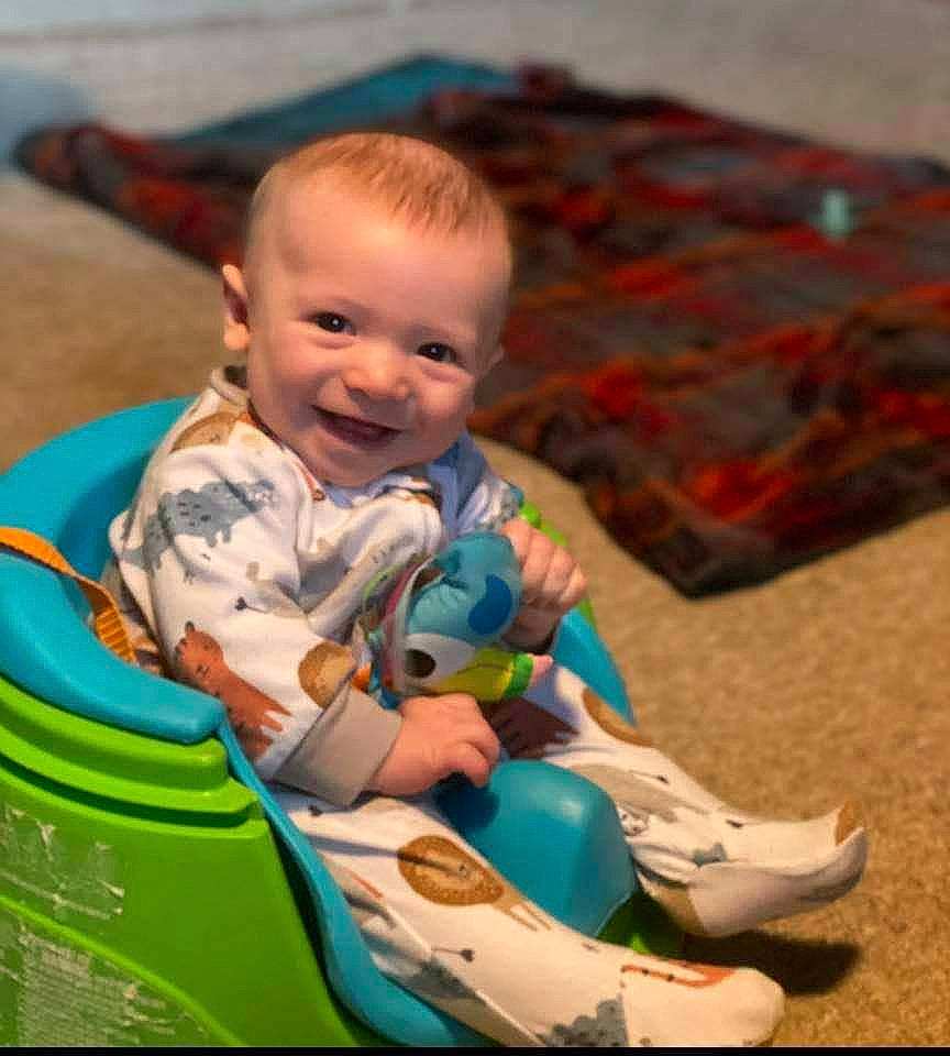 Remington is registered to the contest to win money with this photo: baby, baby_playing_with_toys, baby_products, baby_toddler_clothing, baby_toys, child, comfort, flooring, fun, grass, happy, joy, leisure, person, play, recreation, riding_toy, room, sitting, skin